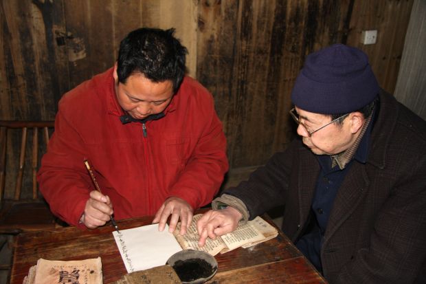 望星楼通书传人李天伦（右）在传授技艺