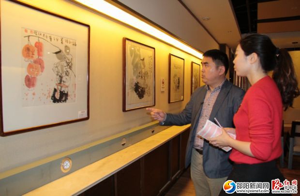 唐爱民向记者介绍湖湘会展展品